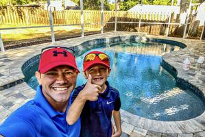 Derek and his son at a freshly cleaned pool